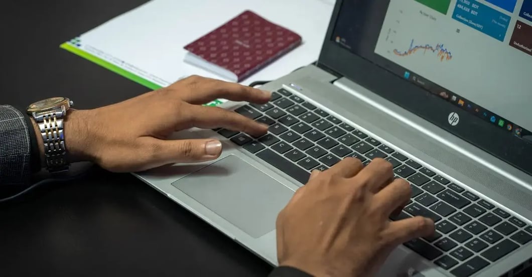 Person typing on laptop with analytics dashboard, troubleshooting why Amazon PPC ads not showing on screen.