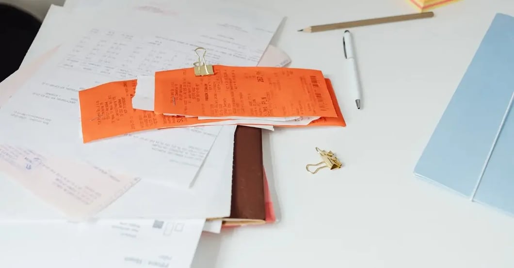 Organized desk workspace showing receipts, documents, and sticky notes for false counterfeit claim evidence collection.