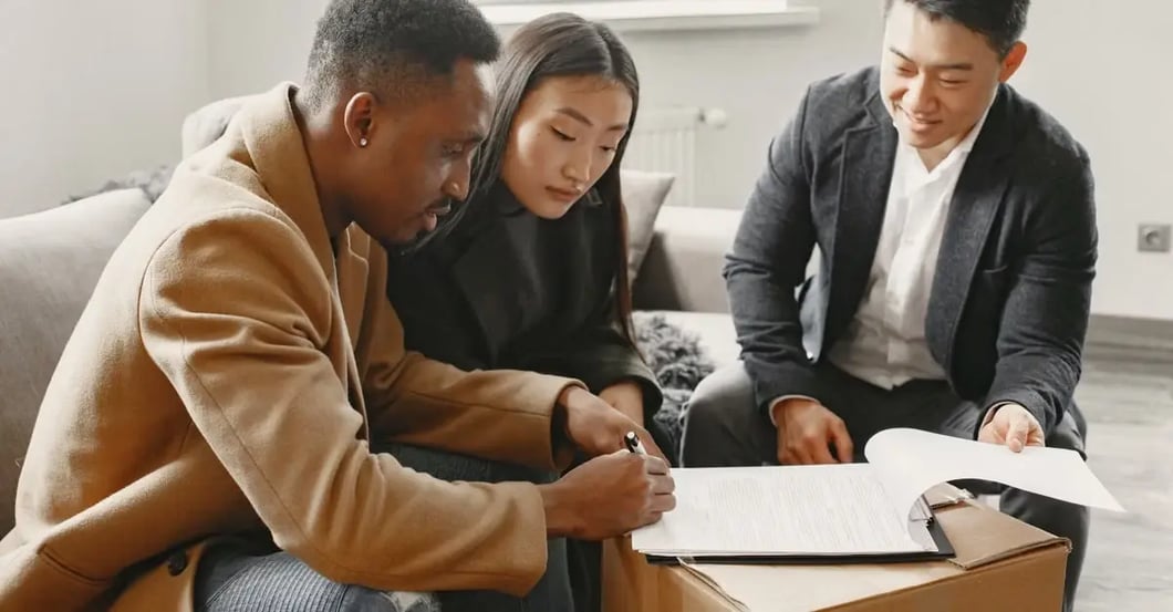 Three professionals reviewing documents together while discussing a false counterfeit claim resolution strategy indoors..