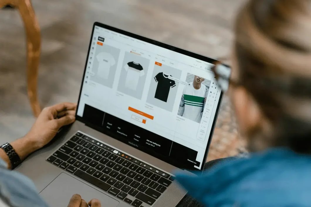 Person viewing an online apparel design or product customization page on a laptop.