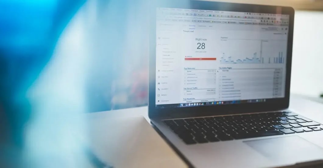 Laptop displaying Amazon PPC optimization dashboard with performance metrics and analytics graphs.