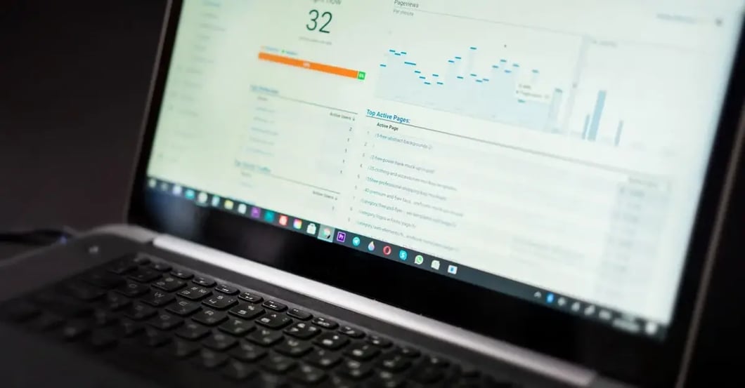 Laptop displaying analytics dashboard with performance score of 32, orange progress bar, and line graph showing Amazon.