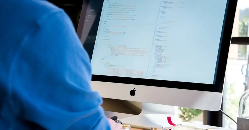Developer reviewing Amazon keyword research code and algorithms on desktop computer monitor.