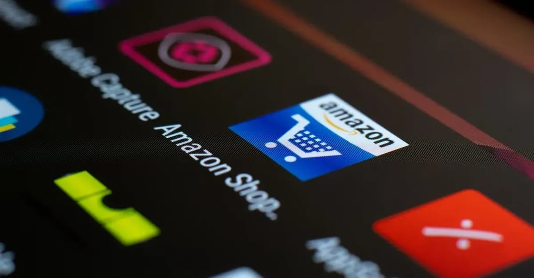 Mobile phone screen displaying Amazon app icon with shopping cart and other retail app icons for seller candy Amazon listing.