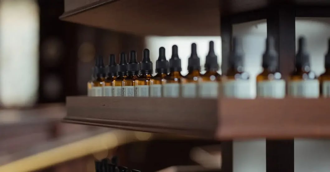 Multiple amber dropper bottles arranged on wooden shelf shelves displaying product bundling organization and storage strategy.