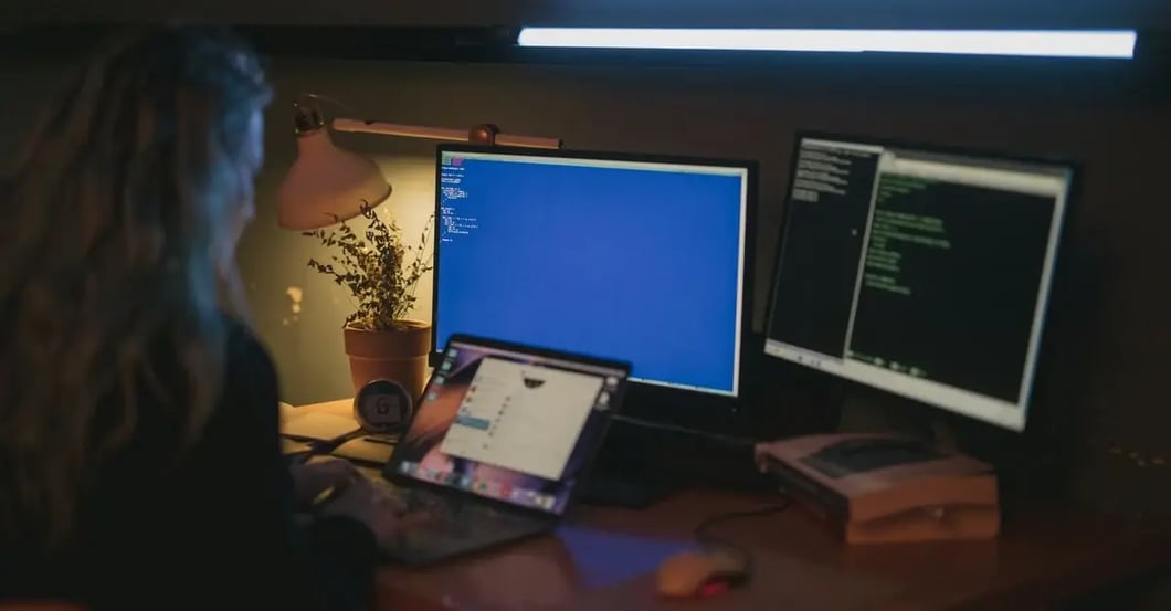 Developer working at multi-monitor setup with Amazon negative keywords research displayed on screen.