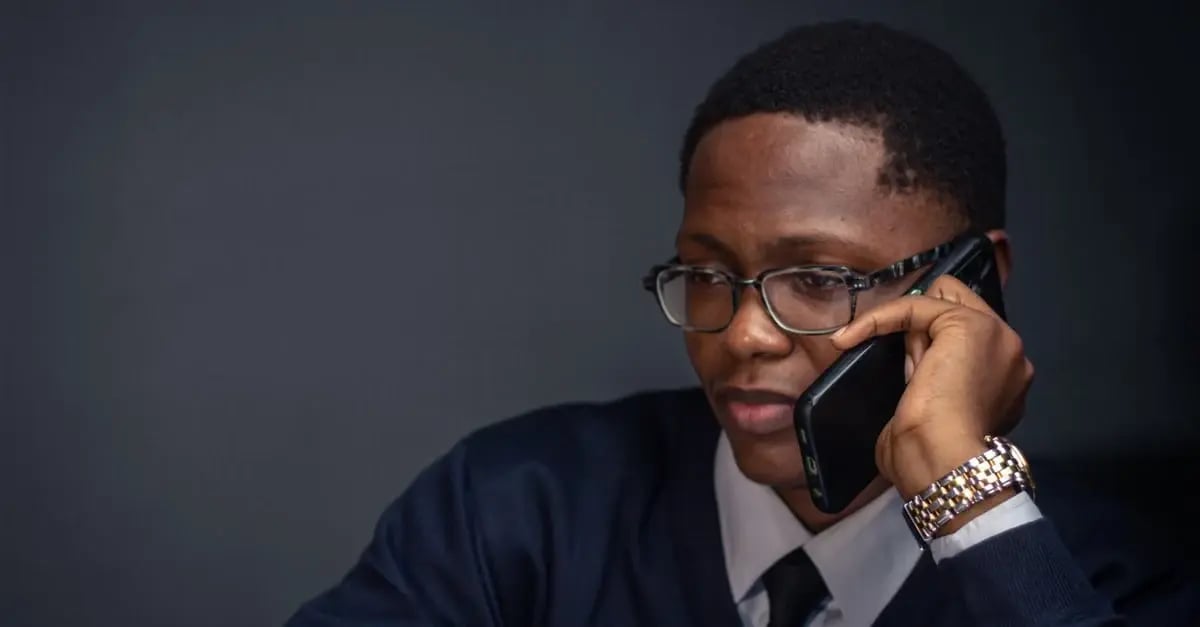 Professional man in glasses speaking on phone during amazon IP complaint negotiation discussion.