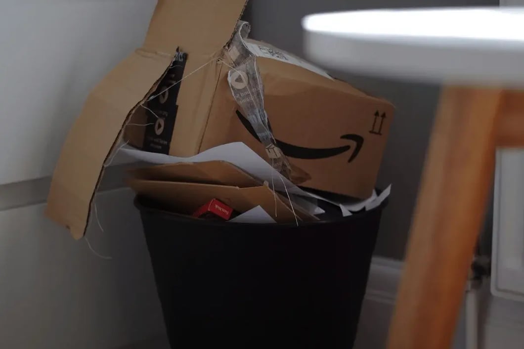 Crushed Amazon box placed in a trash bin after unpacking.