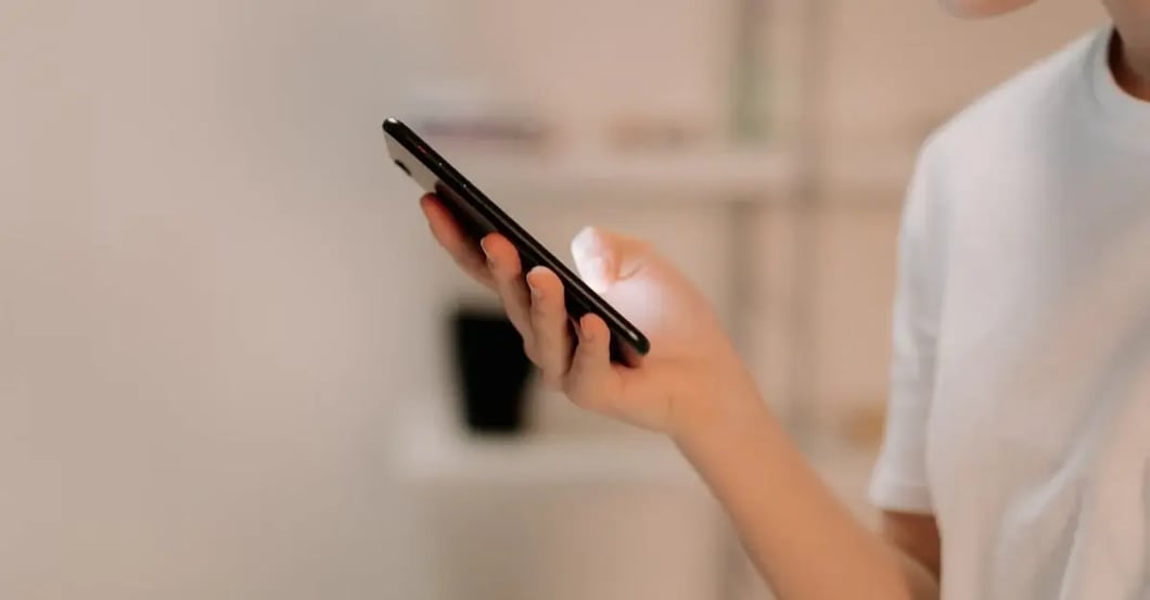 Woman holding smartphone displaying text for amazon product title optimization strategy.